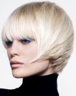 Short blonde bob with full bangs and sides that jut forward