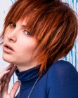 Red hair cut to a short hairstyle with a smooth crown and jagged cutting lines