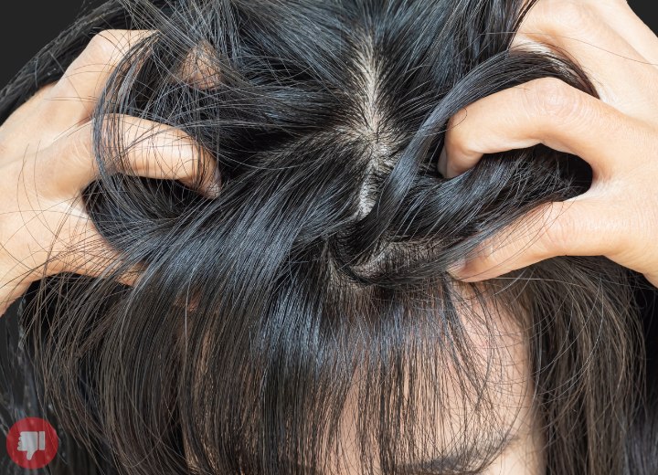 Mujer rasc&aacute;ndose la cabeza