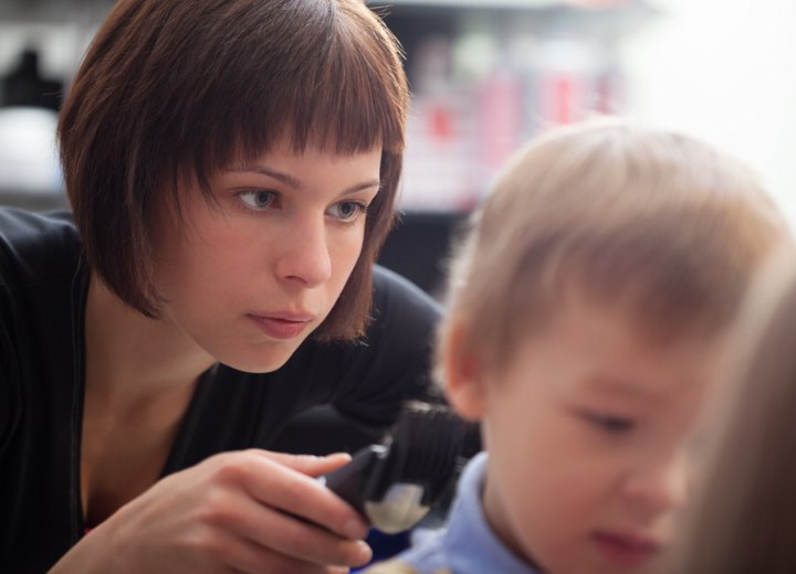 Coiffeuse coupant les cheveux d'un enfant