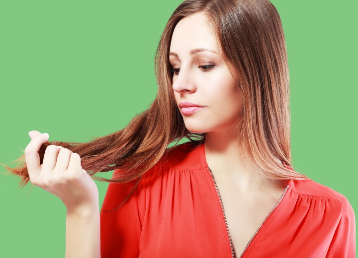 Femme qui inspecte elle-même ses cheveux pour des cheveux gris