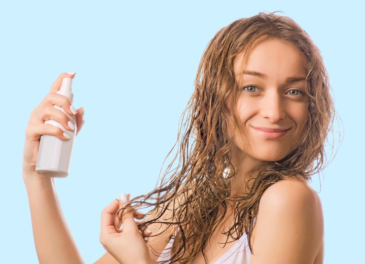 Femme qui utilise un produit hydratant sur ses cheveux