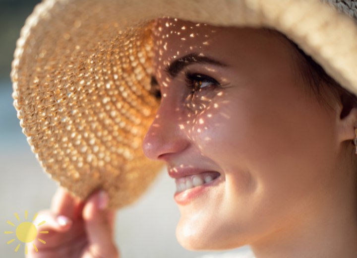 Woman wearing a straw hat to protect her hair from the sun